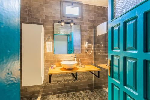 een badkamer met een wastafel en een spiegel bij Avlu Boutique Hotel in Datca