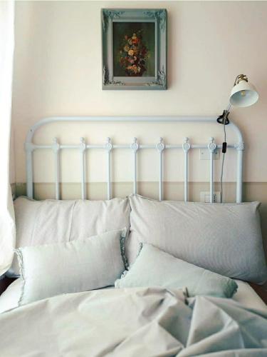 a white bed with pillows and a lamp in a room at La vispa ceresa in Castellinaldo