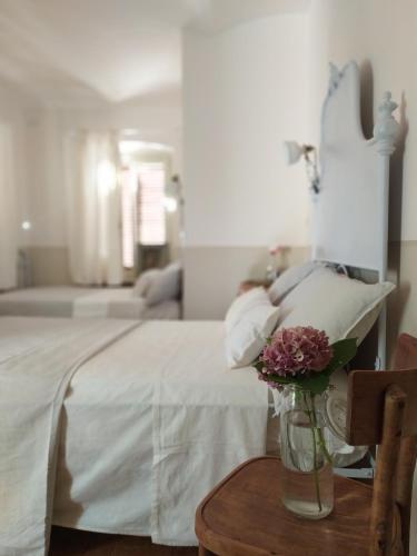 a bedroom with a bed and a vase of flowers on a table at La vispa ceresa in Castellinaldo