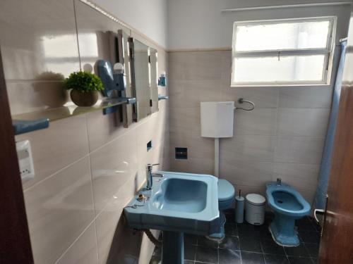 y baño con lavabo azul y aseo. en Hermosa vista, en Colonia del Sacramento