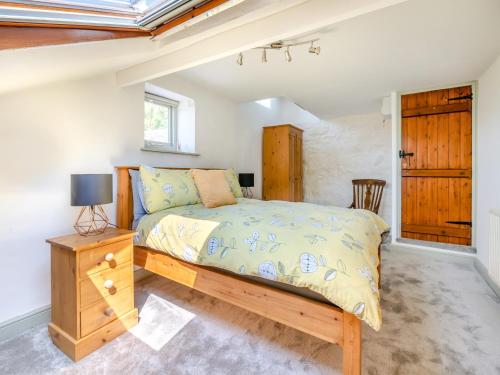 a bedroom with a bed and a table and a window at Kingfisher Barn - Uk44098 in Carsington