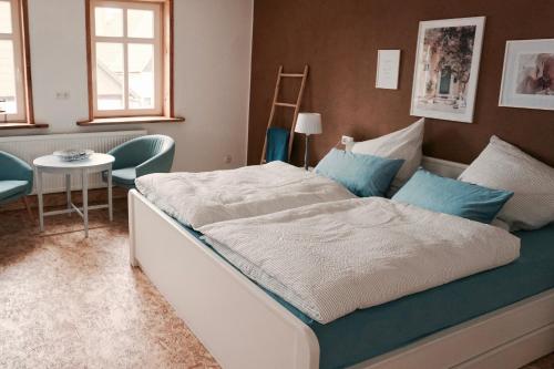 um quarto com uma cama grande e almofadas azuis em Landhaus Weserbergland - Ida em Vahlbruch