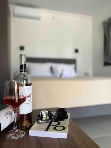 a bottle of wine and glasses on a table at •Naiades Villas• Castalia• in Ladharió