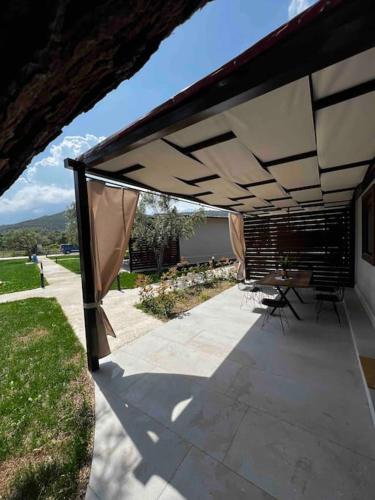 a patio with tables and chairs under an umbrella at •Naiades Villas• Castalia• in Ladharió