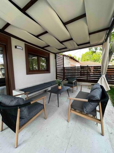 a patio with couches and chairs and a table at •Naiades Villas• Castalia• in Ladharió