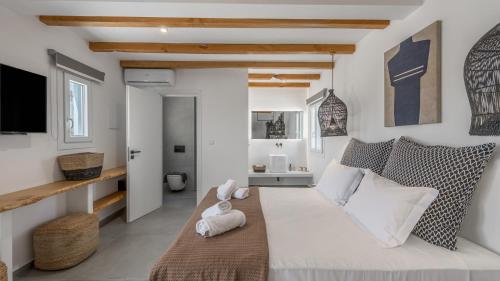 a bedroom with a large bed and a living room at Elements of Milos in Mytakas