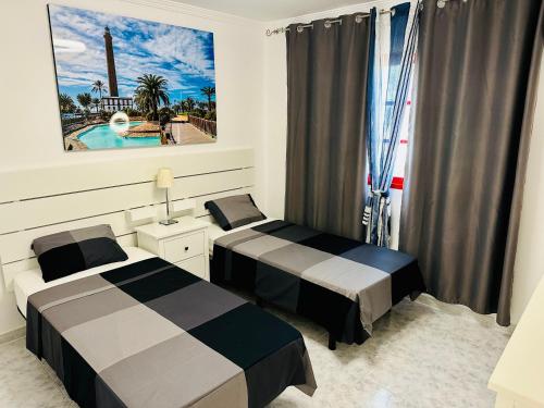 een slaapkamer met 2 bedden en een raam met een zwembad bij Playa del Cura in Playa del Cura