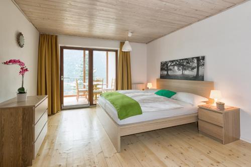 1 dormitorio con 1 cama grande y balcón en Apartments Markus, en Ortisei