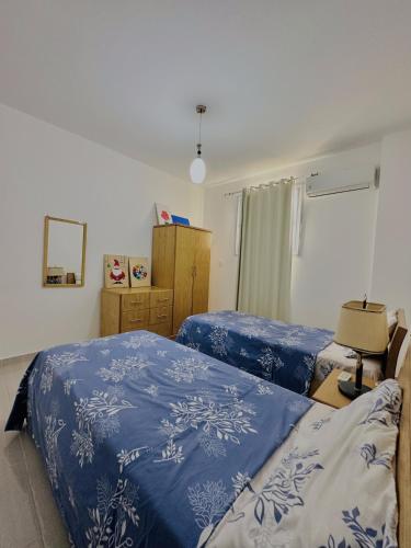 a bedroom with two beds with blue and white sheets at Luxor Rose Villa in Luxor