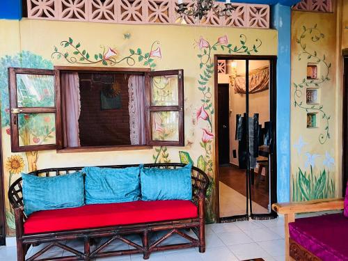 a couch in a room with a painting on the wall at Ananda Guest House Yoga & Meditación in Puerto Escondido