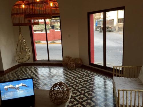 a living room with a couch and a table and windows at Holâ Hotel in La Falda