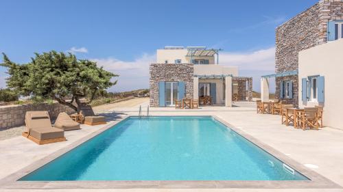 a swimming pool in front of a villa at Elements of Milos in Mytakas