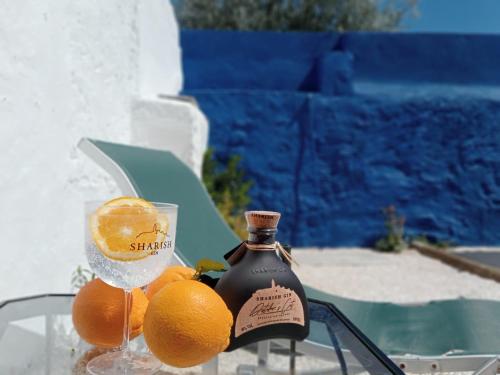una botella de vino y naranjas en una mesa en Bluemoon Campinho (Alqueva), en Campinho