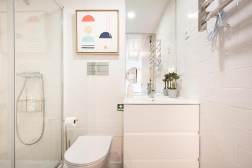 a white bathroom with a toilet and a sink at Casa Barros - Miragaia in Porto