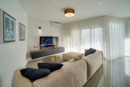 a living room with a couch and a tv at Apartment Hana in Zambratija