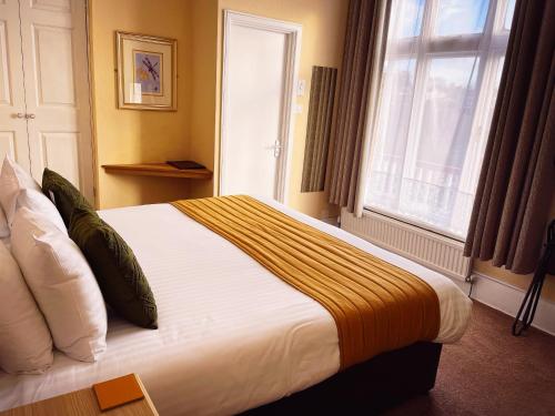 a bedroom with a large bed with a window at The Robin Hill in Torquay