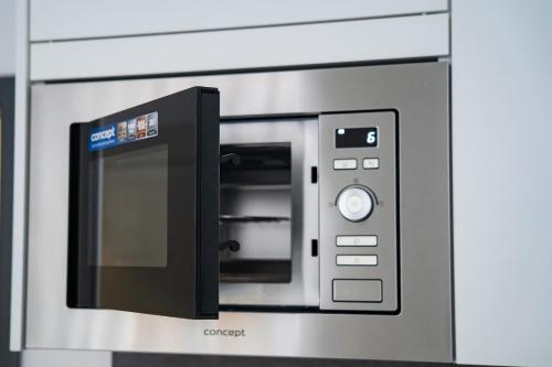 a microwave oven with its door open in a kitchen at Top class apartments in Carlsbad Bulharska street in Karlovy Vary