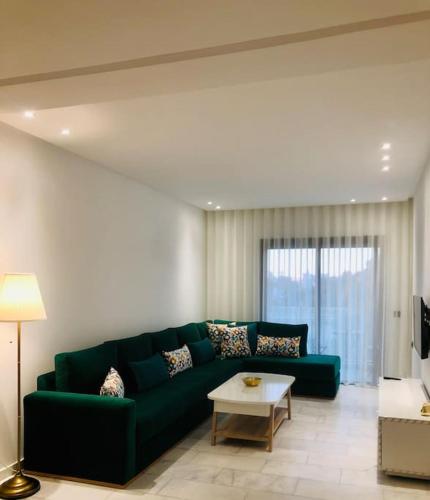 een woonkamer met een groene bank en een tafel bij Appartement de luxe,au Cœur de casa in Casablanca