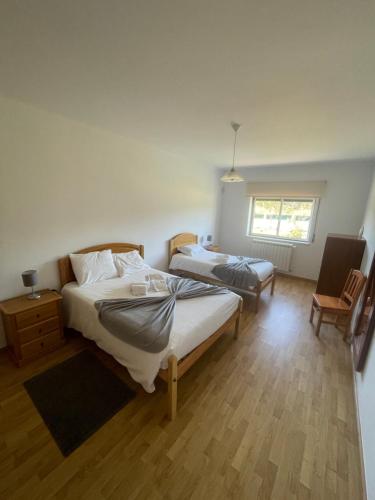 1 dormitorio con 2 camas y ventana en Paraíso do Quim en São Martinho do Porto
