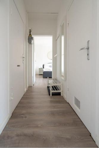 a hallway with white walls and a wooden floor at Gemütliche 2-Zimmer-Wohnung in Neustadt in Holstein