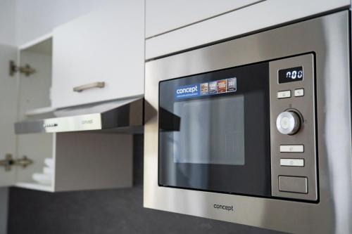a stainless steel microwave oven in a kitchen at Top class apartments in Carlsbad Bulharska street in Karlovy Vary