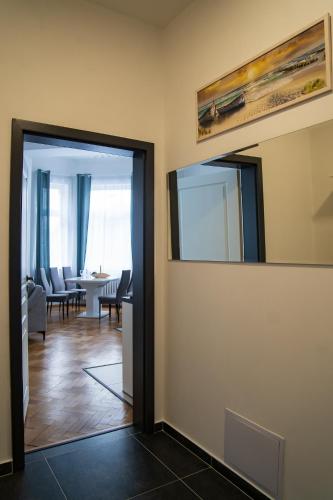 a hallway with a mirror and a dining room at Top class apartments in Carlsbad Bulharska street in Karlovy Vary