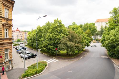 a city street with cars parked in a parking lot at Top class apartments in Carlsbad Bulharska street in Karlovy Vary