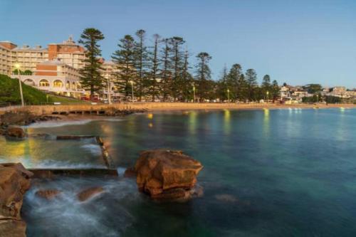 une masse d'eau avec des rochers dans l'eau dans l'établissement Nissaki@Terrigal - Luxury Studio Apartment, à Terrigal