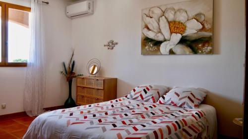 une chambre avec un lit et un tableau au mur dans l'établissement Bas de villa vue mer & piscine, à Coti-Chiavari