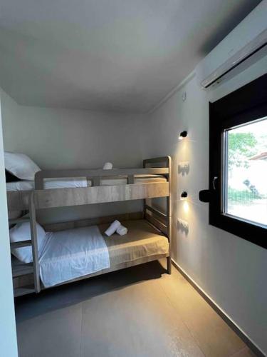 a bedroom with bunk beds and a window at •Naiades Villas•Meliti• in Ladharió
