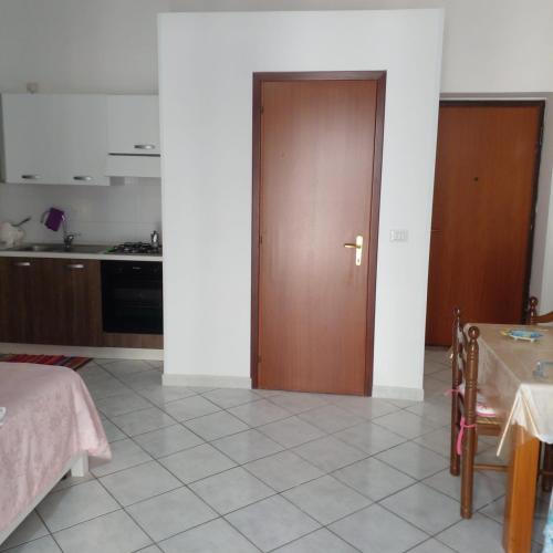 a kitchen with a brown door and a table at Casa Margherita piano primo in Mondragone
