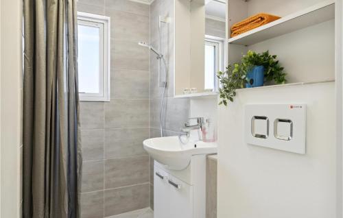 uma casa de banho branca com um lavatório e um chuveiro em Beautiful Apartment In Blokhus With Kitchen em Blokhus