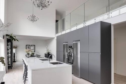 a kitchen with white cabinets and a white counter top at Villa Maitri in Alvesta