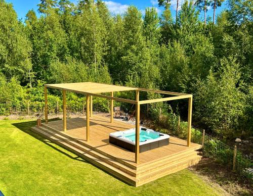 a hot tub on a deck with a gazebo at Villa Maitri in Alvesta