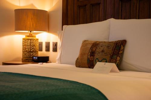 a bed with a lamp and a pillow on it at Casa 1810 Parque Hotel Boutique in San Miguel de Allende