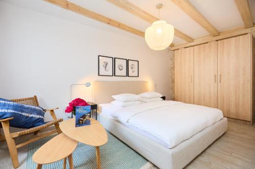 um quarto com uma cama branca e uma cadeira em Stone Elegance em Dubrovnik