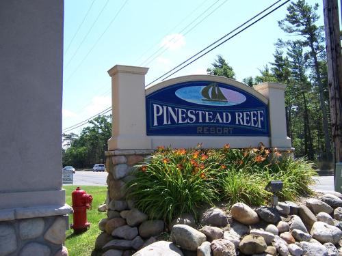 a sign for a pincher reef resort with a fire hydrant at Pinestead Reef Resort in Traverse City