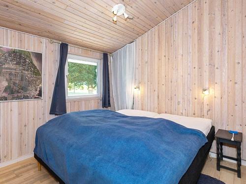 a bedroom with a large bed in a wooden wall at 7 person holiday home in Højslev-By Traum in Højslev