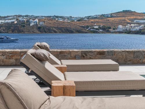 patio z 2 leżakami i widokiem na wodę w obiekcie Star villa by Bestofmikonos w mieście Mykonos