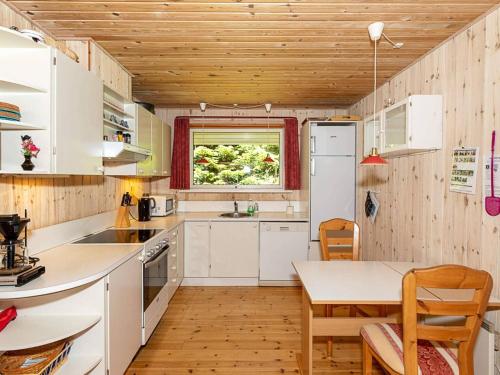 een keuken met witte apparatuur en een houten plafond bij 10 person holiday home in H jslev in Bøstrup