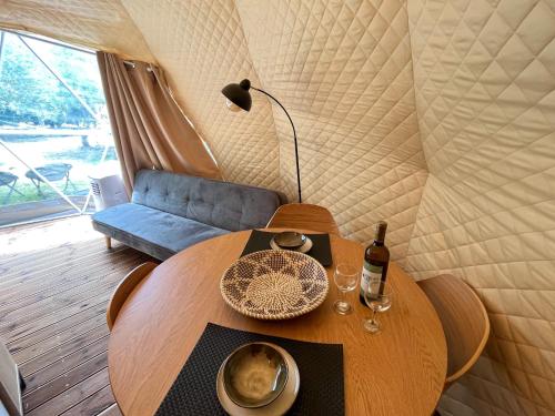 a table with a bottle of wine and glasses on it at Manna Gea Glamping Domes in Vonitsa