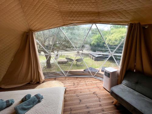 Zimmer mit einem Zelt und einem großen Fenster in der Unterkunft Manna Gea Glamping Domes in Vónitsa