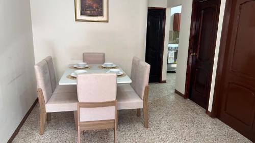 - une table à manger avec des chaises et des assiettes dans l'établissement NCG SUITE Comegua, à Guayaquil