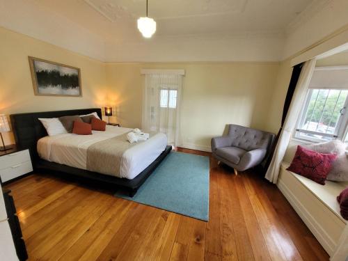 een slaapkamer met een bed en een stoel bij Spacious home close to CBD and Airport in Brisbane