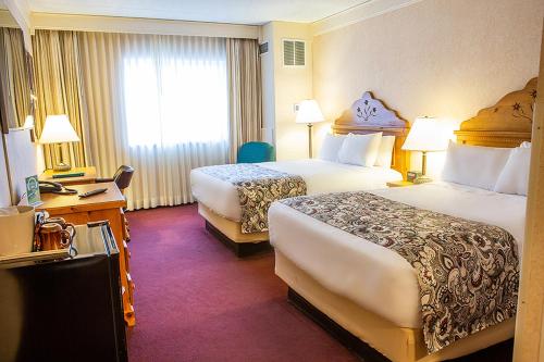 a hotel room with two beds and a desk at Bavarian Inn Lodge in Frankenmuth