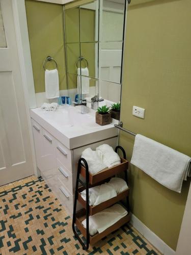 een badkamer met een wastafel en een spiegel bij Spacious home close to CBD and Airport in Brisbane