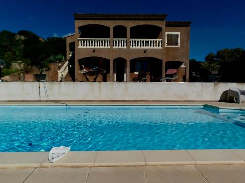 une maison avec une piscine devant une maison dans l'établissement Bas de villa vue mer & piscine, à Coti-Chiavari