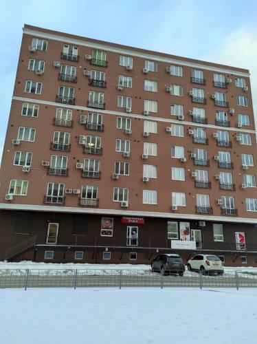 a large building with cars parked in front of it at Затишна студія, 5 хвилин від Південного вокзалу in Kharkiv