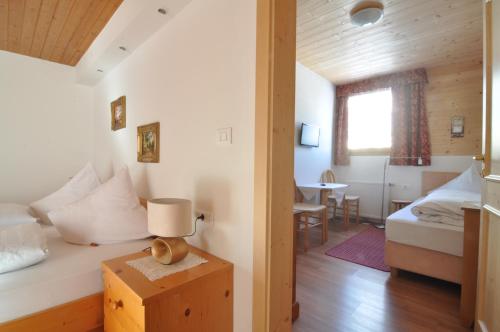 a bedroom with a bed and a table with a lamp at Hotel Traube - Stelvio in Stelvio