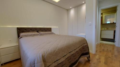 sypialnia z dużym łóżkiem w białym pokoju w obiekcie Vista do Lago w mieście Canela